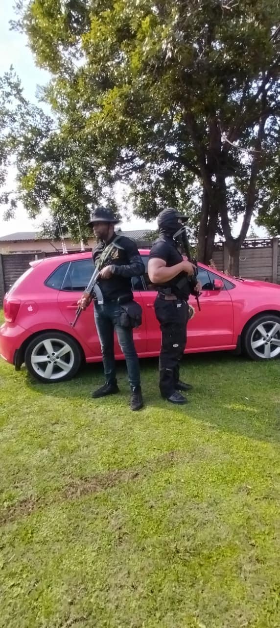Two armed officers deployed from a branded response vehicle