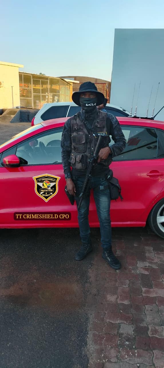 Armed officer alongside a branded TT Crimeshield response vehicle