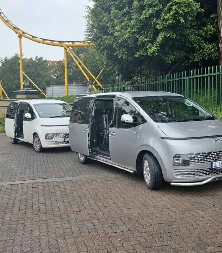 Two Staria people-movers loading for a group transfer
