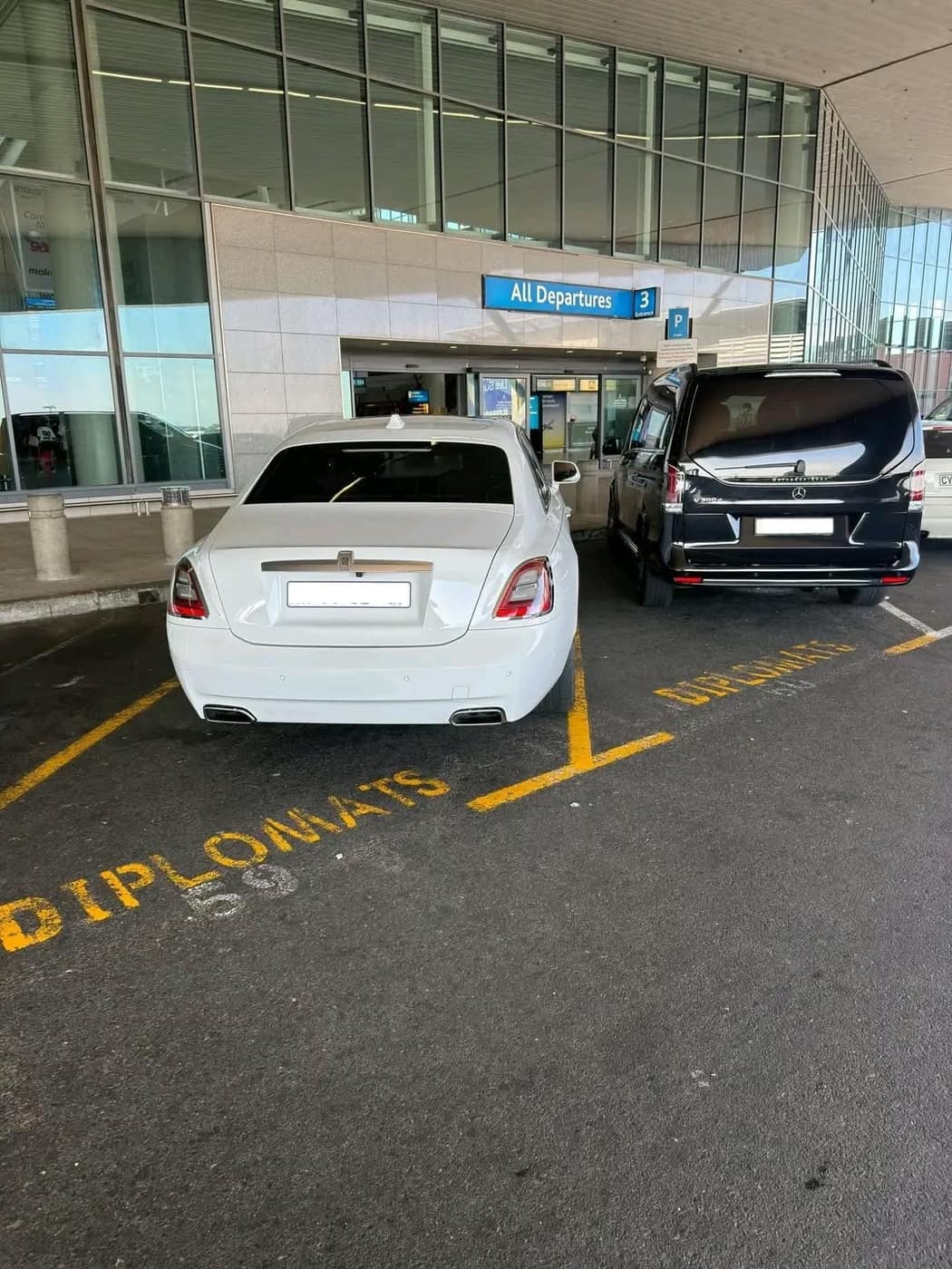 Rolls-Royce and escort vehicle at airport departures